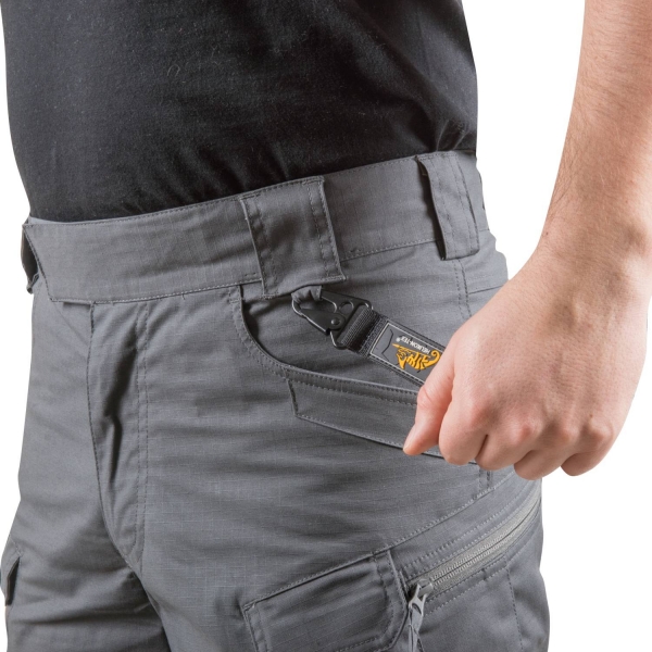 Ein Mann trägt die graue Helikon Tex Short mit der linken Hand an der Hosentaschen.