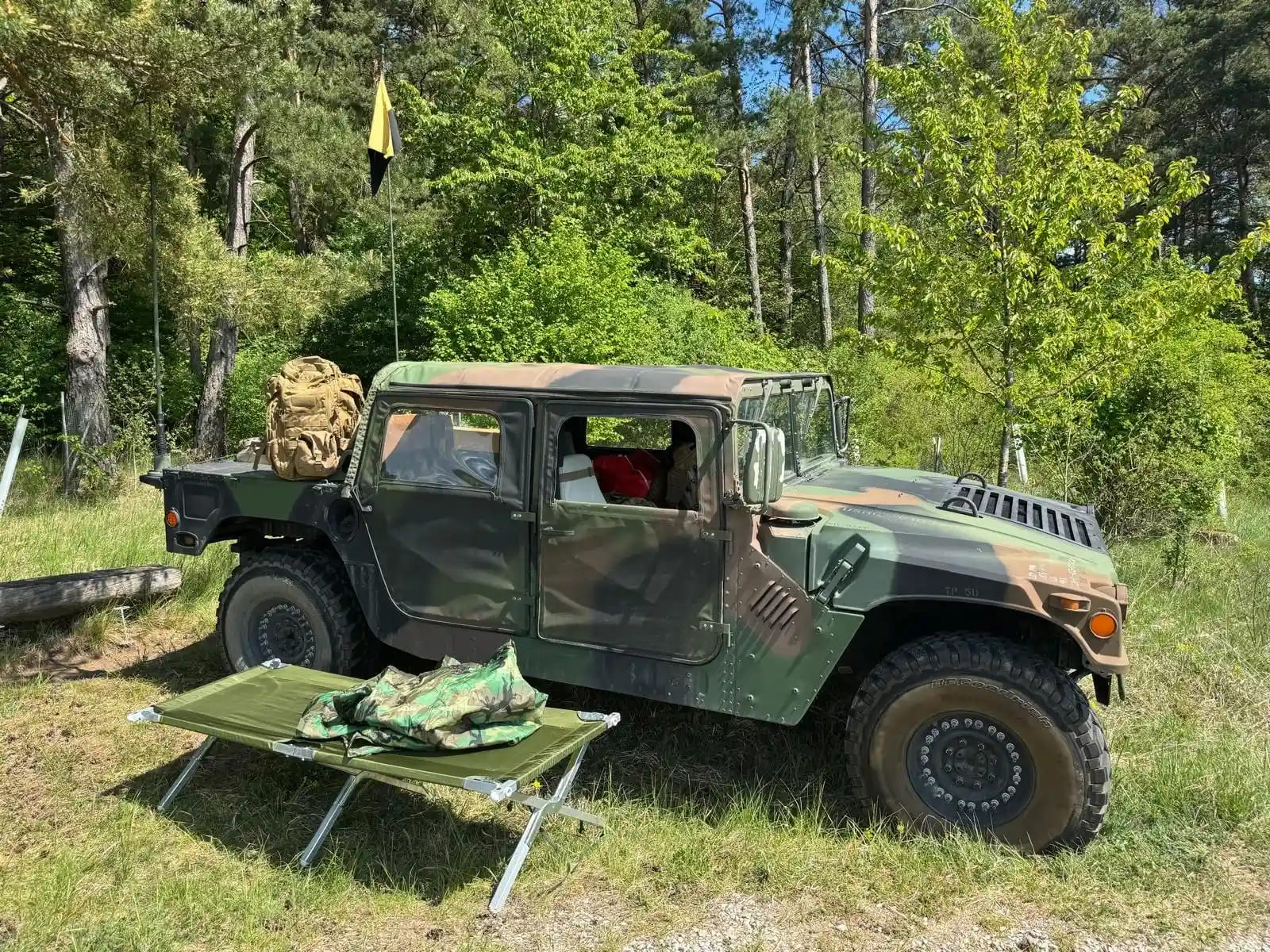 Ein Como farbenes Militärfahrzeug steht im Wald.